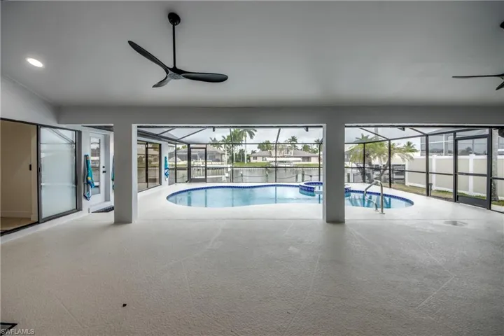 View of swimming pool featuring ceiling fan