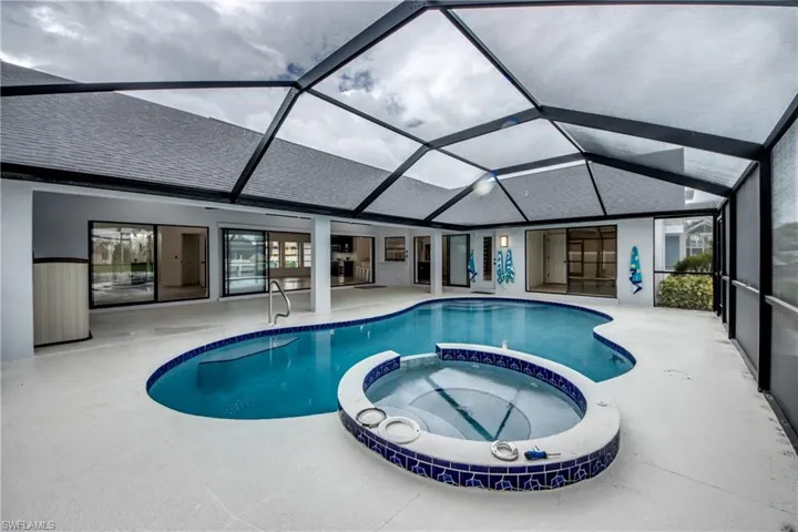 View of swimming pool with a lanai, an in ground hot tub, and a patio