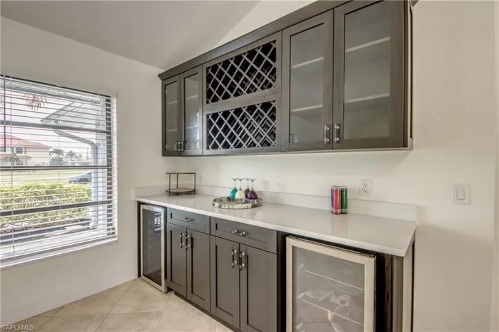 Bar with beverage cooler and light tile flooring