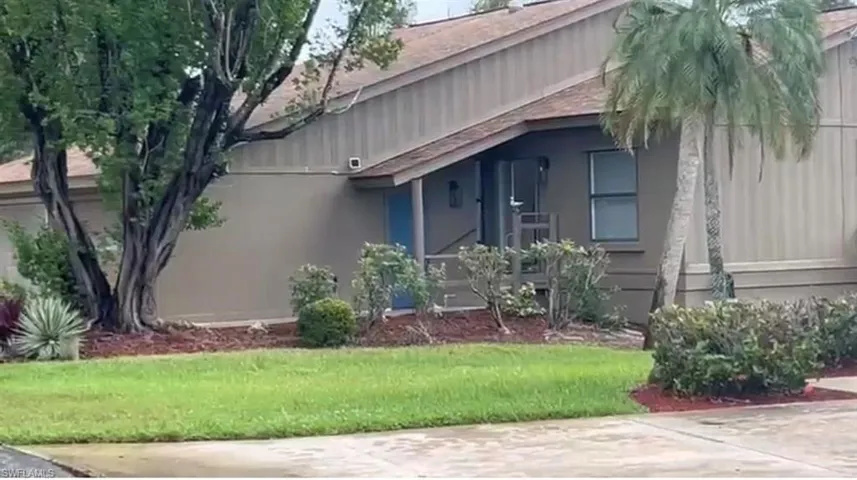 View of side of property with a yard and roof with shingles