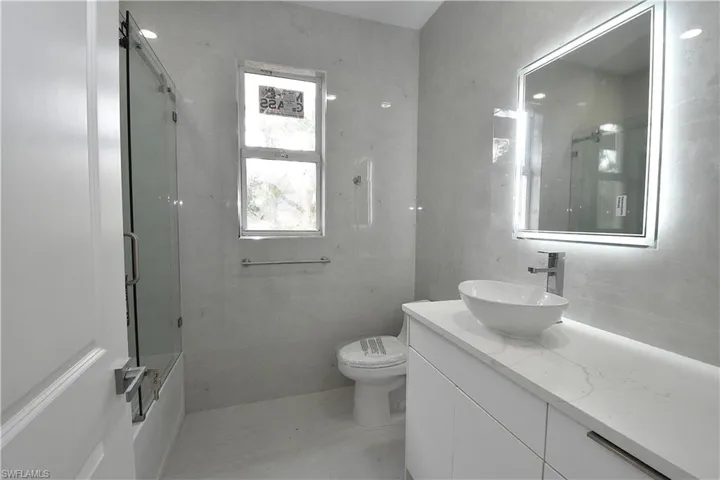 Bathroom, featuring basin sink and lit mirror.
