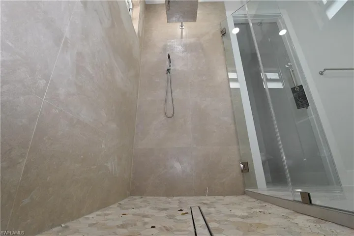 primary bath shower area, featuring wall tile all the way to te ceiling.