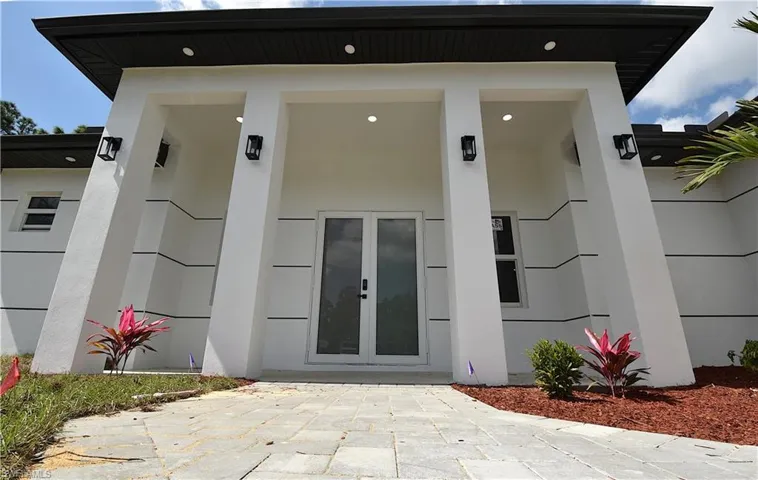 Elegant entrance. Tall columns, paved side walk.