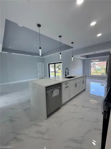 Kitchen featuring dishwasher, a sink, marble finish floor, a kitchen island with sink, and open floor plan