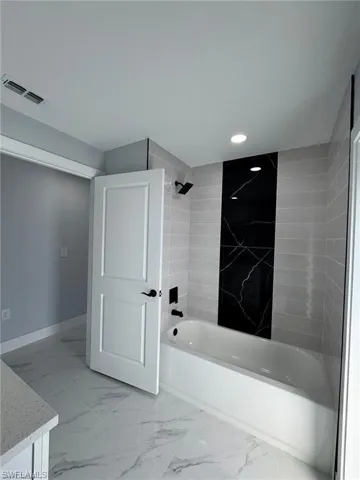 Full bathroom featuring visible vents, recessed lighting, marble finish floor, and shower / washtub combination