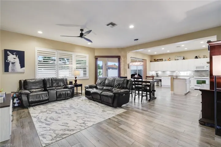 Living room featuring french doors, sink, ceiling fan, and light wood-type flooring