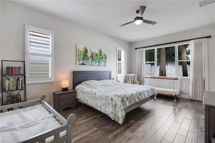 Bedroom with ceiling fan and dark wood-type flooring