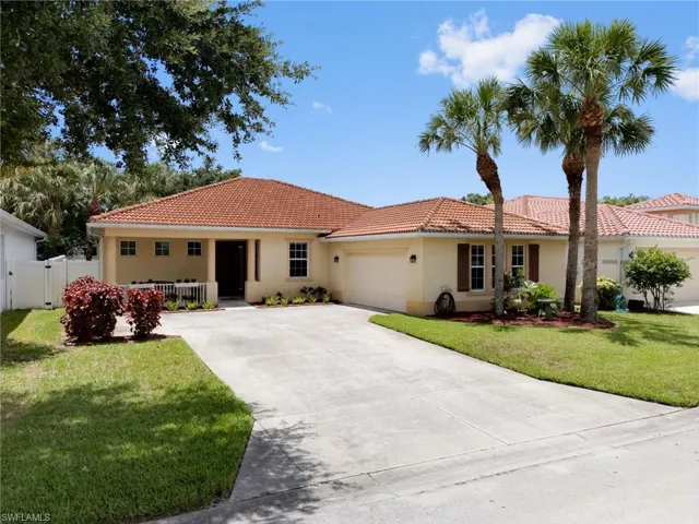 Mediterranean / spanish home with a garage and a front yard