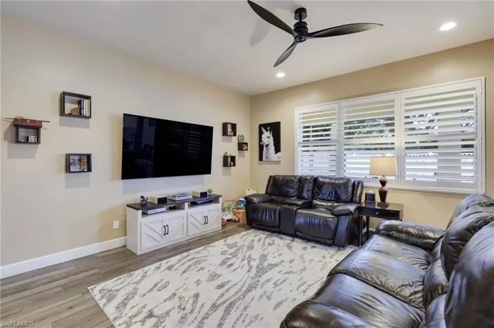 Living room with light hardwood / wood-style floors and ceiling fan