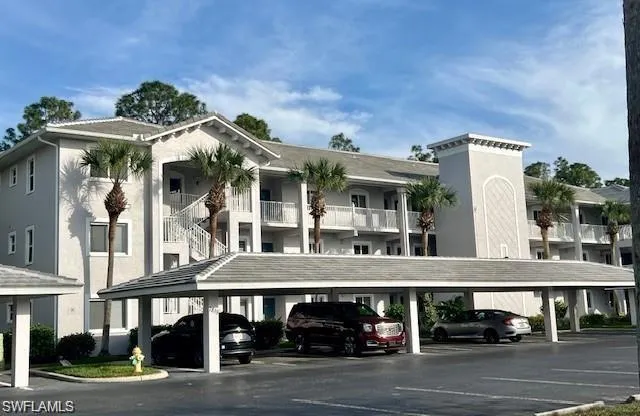 View of building exterior featuring covered parking