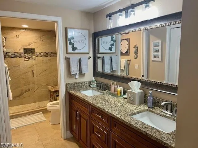 Full bathroom with double vanity, a stall shower, and light tile patterned floors