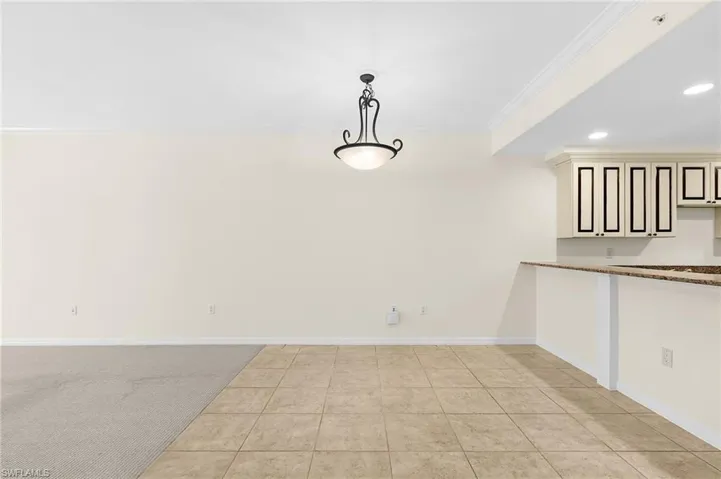 Open-concept living space featuring a combination of carpet and tiled flooring