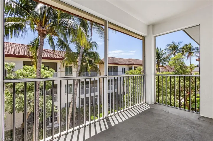 Screened balcony featuring a concrete floor and black metal railings