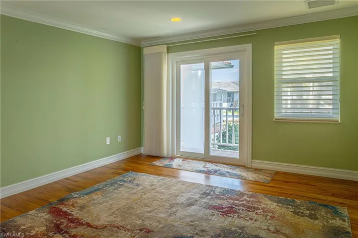 Entryway with ornamental molding, baseboards, and wood finished floors