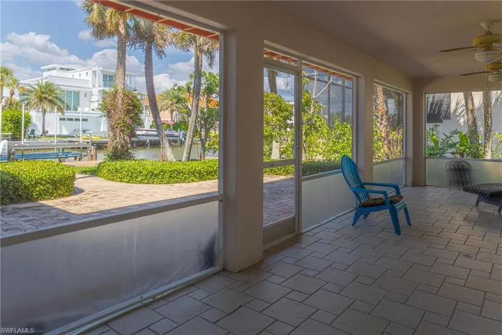 Unfurnished sunroom featuring a water view, a ceiling fan, and plenty of natural light
