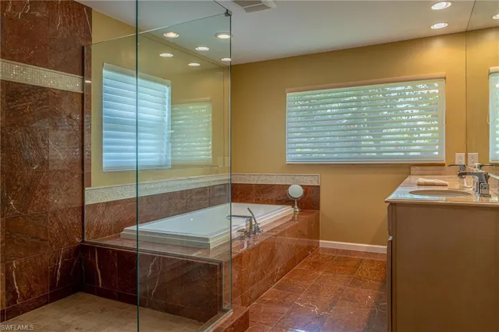 Full bath with a walk in shower, recessed lighting, vanity, and a garden tub