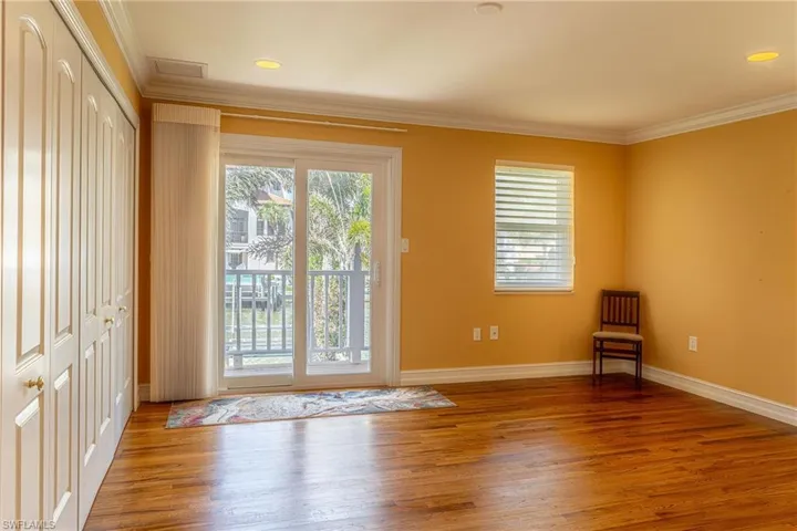 Doorway with recessed lighting, baseboards, ornamental molding, and wood finished floors