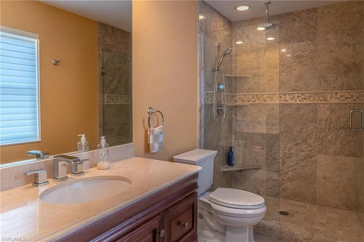 Full bathroom featuring a shower stall, vanity, and toilet