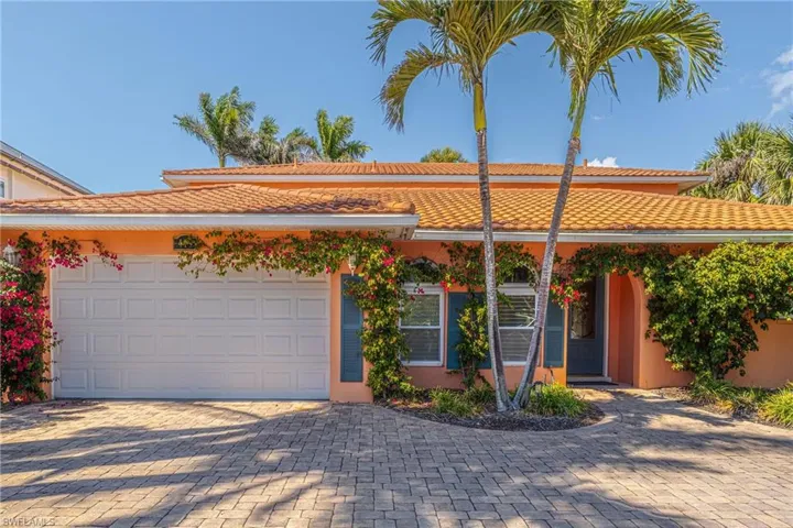 Ranch-style home with stucco siding, a tiled roof, decorative driveway, and an attached garage