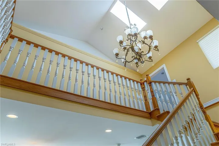 Staircase featuring high vaulted ceiling, a notable chandelier, visible vents, and recessed lighting