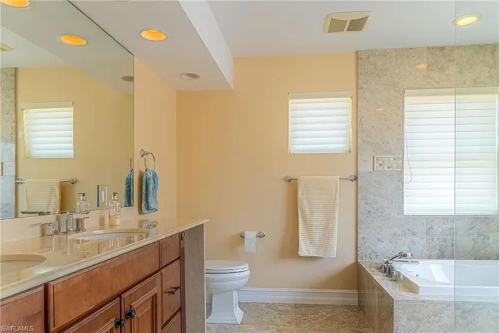 Full bathroom featuring a bath, visible vents, baseboards, and plenty of natural light