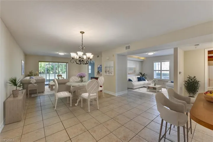 View of Dining Area, Den, Great Room and Lanai from Entry Hallway. Virtually Staged.