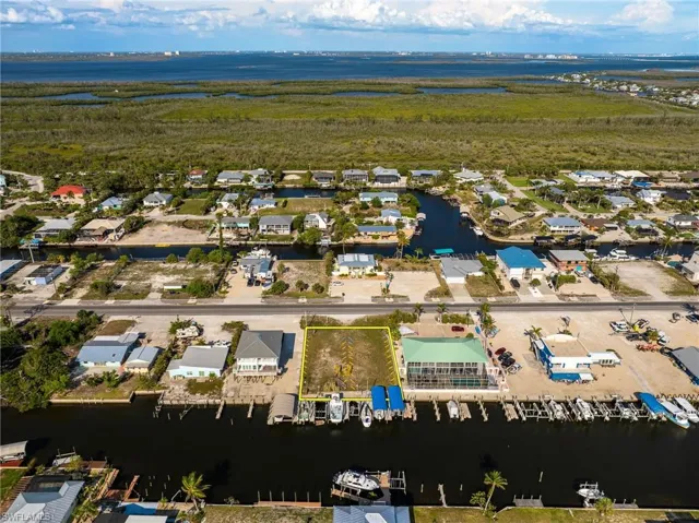 Aerial view of property's location with a large body of water and nearby suburban area