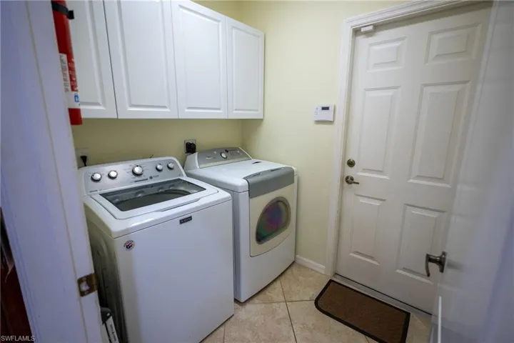 Entrance to garage from house and laundry room with extra storage.