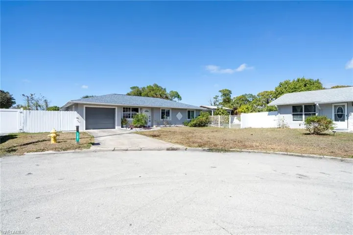 Single story home with concrete driveway and an attached garage