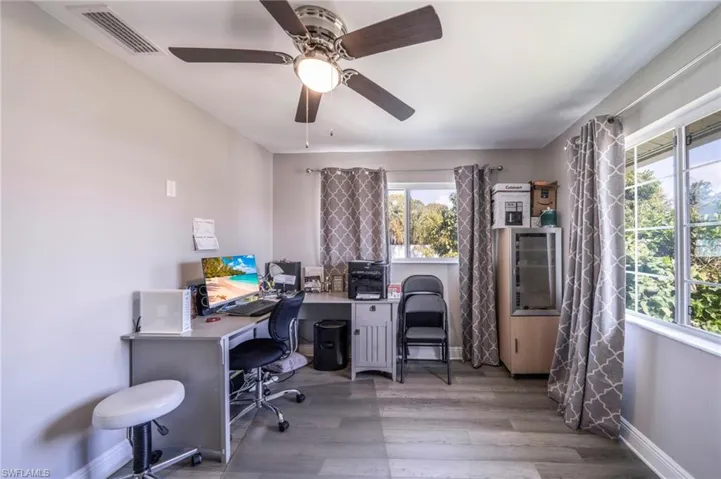 Office space with wood finished floors and a ceiling fan