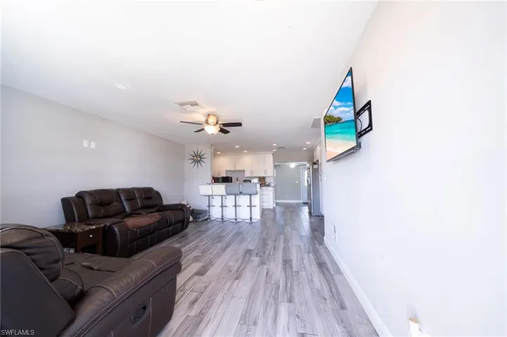 Living room with light wood-style flooring and ceiling fan