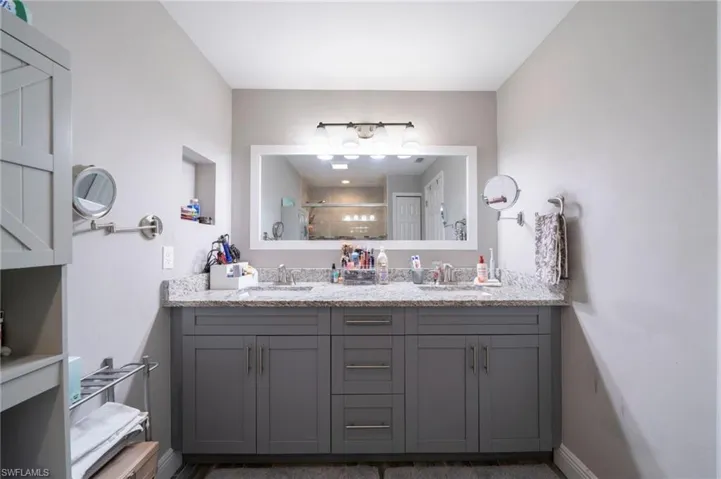 Full bath with double vanity and a tile shower