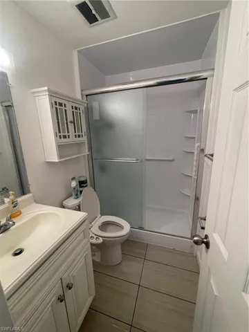 Bathroom featuring vanity, a shower stall, and light tile patterned floors