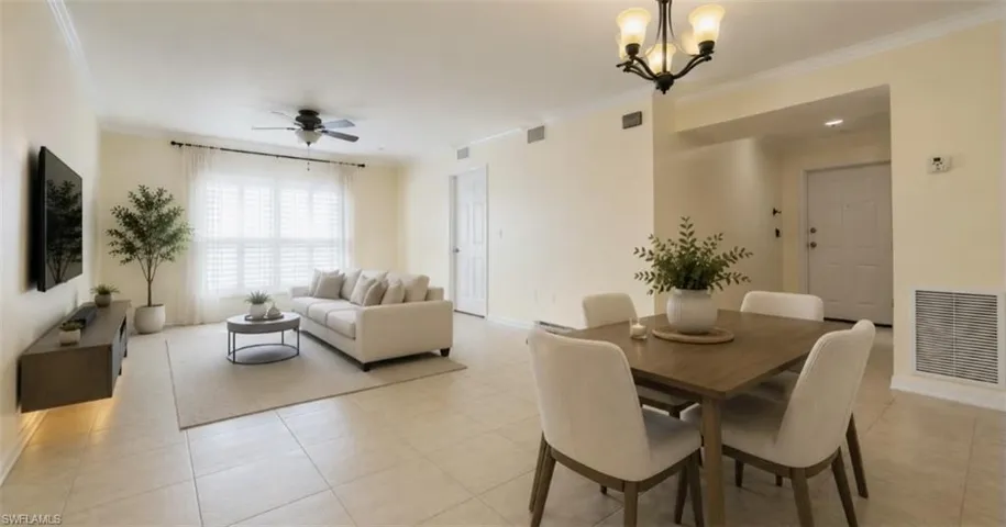 Virtually staged: Open-concept living area featuring tile flooring, a ceiling fan, and a dining area with a chandelier