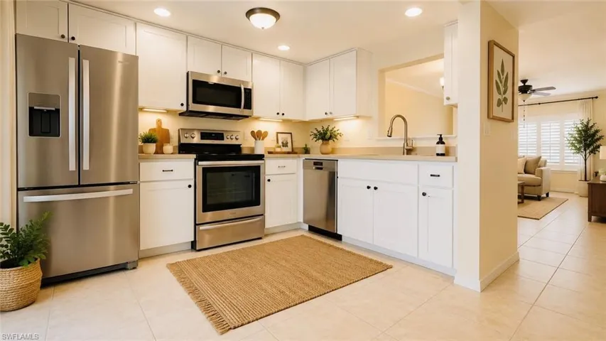 Contemporary kitchen featuring white cabinetry, stainless steel appliances, light-toned countertops, and tile flooring