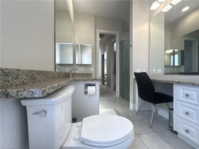 Spacious en-suite primary bath featuring dual vanities, a soaking tub, a unique walk-through shower with dual entrances, and two private water closets for added comfort and convenience