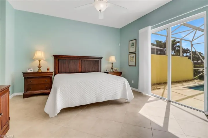 Bedroom featuring access to exterior, a sunroom, light tile patterned flooring, and baseboards
