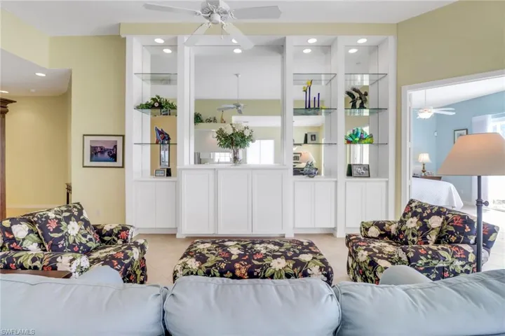 Living area with ceiling fan, recessed lighting, and built in features