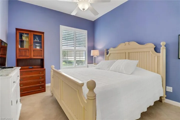Bedroom with ceiling fan, light tile patterned flooring, and baseboards