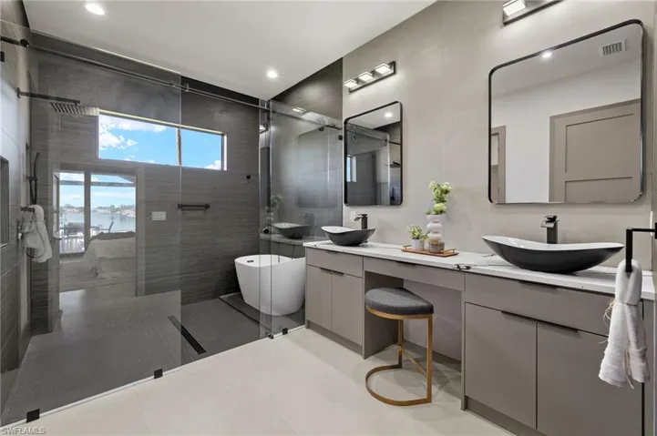 Bathroom featuring vanity, a water view, separate shower and tub, and tile patterned flooring
