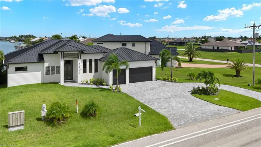 View of front of home featuring a garage, a front yard, and a water view