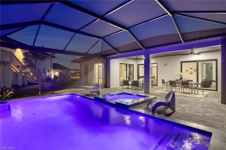 View of swimming pool featuring a lanai, an in ground hot tub, ceiling fan, and a patio