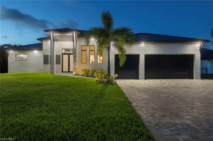 View of front facade with a yard and a garage