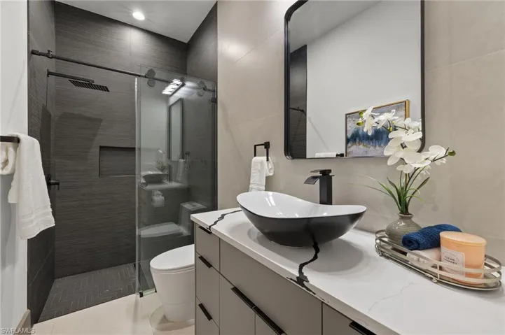 Bathroom with tile patterned flooring, vanity, toilet, and walk in shower