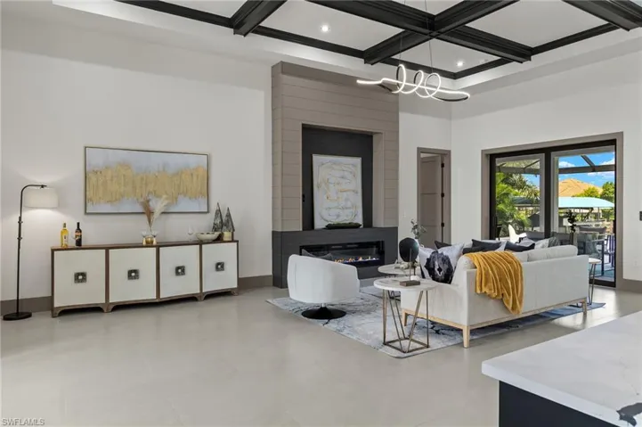 Living room featuring coffered ceiling, beam ceiling, and a fireplace