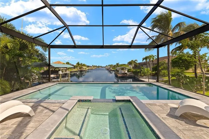 View of pool featuring a lanai, a patio, and a water view