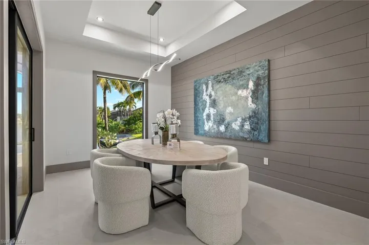 Dining space with wood walls and a tray ceiling