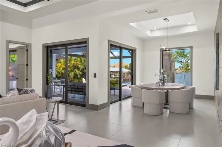 Dining area featuring a water view, light tile patterned floors, and a tray ceiling