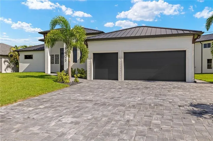 Ranch-style house featuring a garage and a front lawn