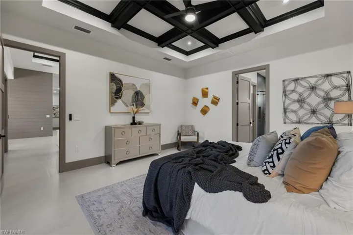 Bedroom with coffered ceiling, ceiling fan, and beamed ceiling